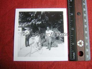 PHOTO B7074 People watching child on bouncy horse under tree