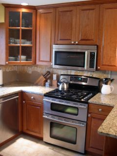 Base, wall and bridge cabinets surround the stove and microwave