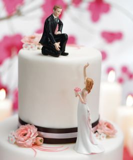 reaching bride and helpful groom cake top